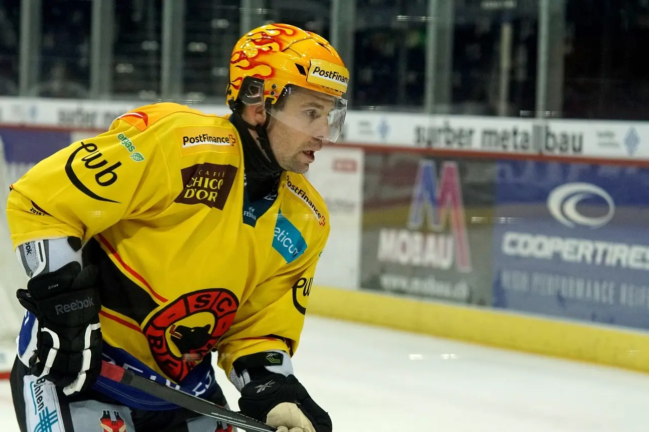 Ishockeyspiller i gul trøje på isen