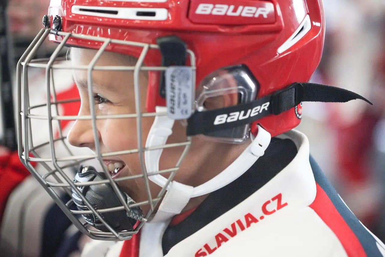 Smilende ishockeyspiller med rød hjelm